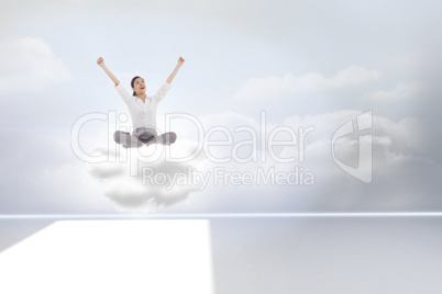 Composite image of cheering businesswoman sitting cross legged