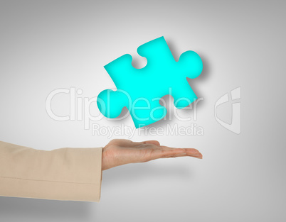 Composite image of female hand presenting jigsaw piece