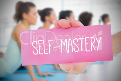Woman holding pink card saying self mastery