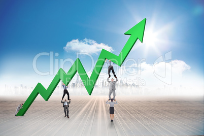 Composite image of business team holding up arrow