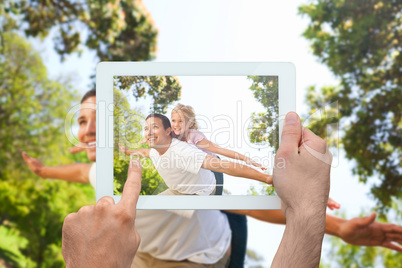 Composite image of hand holding tablet pc