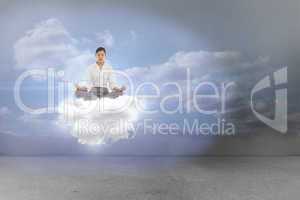 Composite image of businesswoman sitting in lotus pose