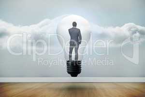 Composite image of thinking businessman in light bulb