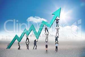 Composite image of business team holding up arrow