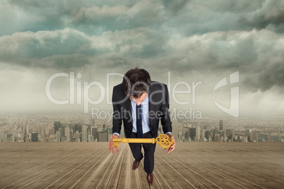 Composite image of businessman carrying large key