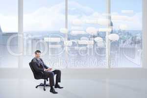 Composite image of young businessman sitting working with a lapt