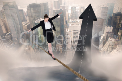 Composite image of businesswoman performing a balancing act