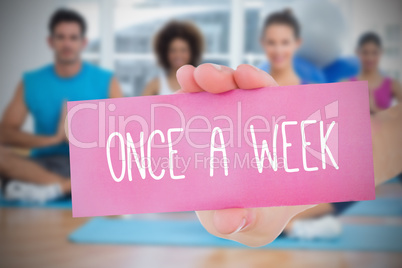Woman holding pink card saying once a week