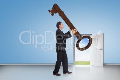 Composite image of stressed businessman carrying large key