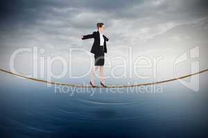 Composite image of businesswoman performing a balancing act