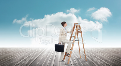 Composite image of businesswoman climbing career ladder with bri