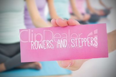 Woman holding pink card saying rowers and steppers