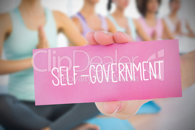 Woman holding pink card saying self government