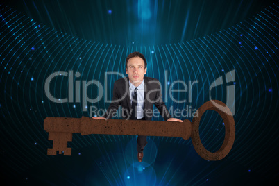 Composite image of businessman carrying large key