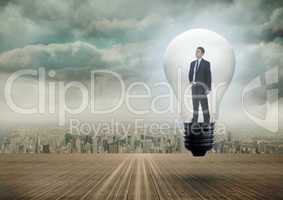 Composite image of thinking businessman in light bulb