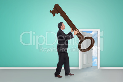 Composite image of stressed businessman carrying large key