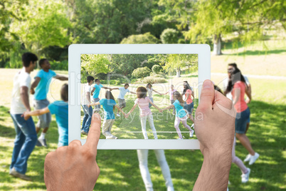 Composite image of hand holding tablet pc