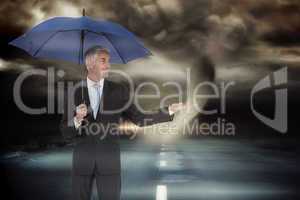 Composite image of happy businessman holding umbrella