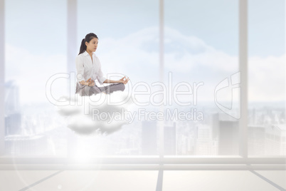 Composite image of businesswoman sitting in lotus pose