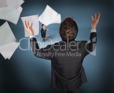 Composite image of gesturing businessman with tiny businessman