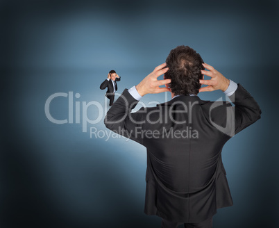 Composite image of stressed businessman with hands on head with