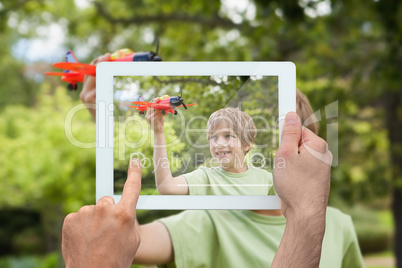 Composite image of hand holding tablet pc