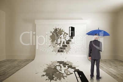 Composite image of businessman holding umbrella