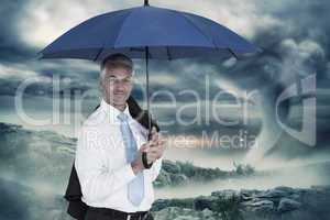 Composite image of businessman holding blue umbrella