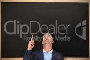 Composite image of cheerful businessman pointing upward