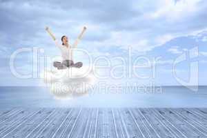 Composite image of cheering businesswoman sitting cross legged