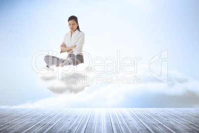 Composite image of annoyed businesswoman sitting with arms cross