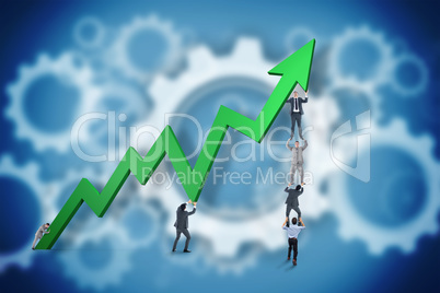 Composite image of business team holding up arrow