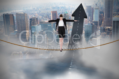 Composite image of businesswoman performing a balancing act