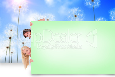Composite image of attractive couple showing card
