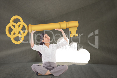 Composite image of businesswoman sitting cross legged carrying l