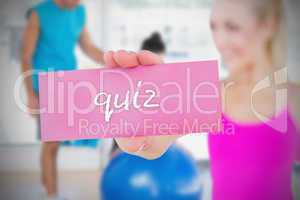 Fit blonde holding card saying quiz