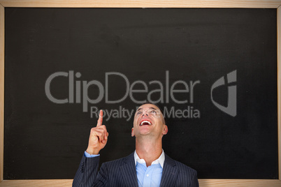 Composite image of cheerful businessman pointing upward