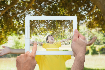 Composite image of hand holding tablet pc