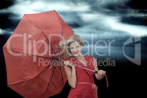 Composite image of smiling blonde holding umbrella