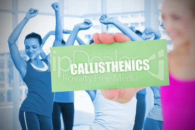 Fit blonde holding card saying callisthenics