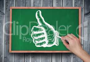 Composite image of hand drawing thumbs up with chalk