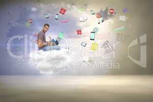 Composite image of man wearing glasses sitting on floor using la