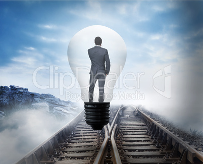 Composite image of thinking businessman in light bulb