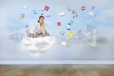 Composite image of businesswoman sitting cross legged thinking