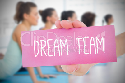 Woman holding pink card saying dream team
