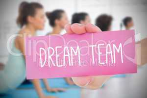 Woman holding pink card saying dream team