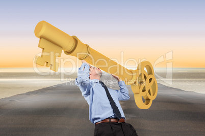 Composite image of businessman carrying large key