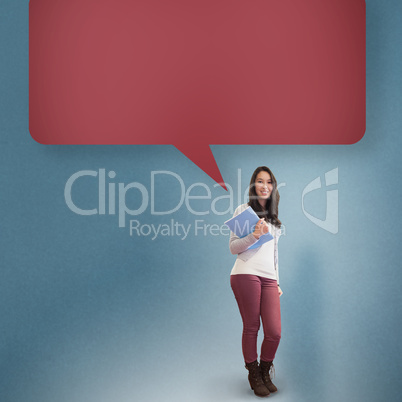 Composite image of smiling student holding textbook with speech