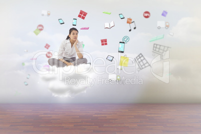 Composite image of businesswoman sitting cross legged thinking