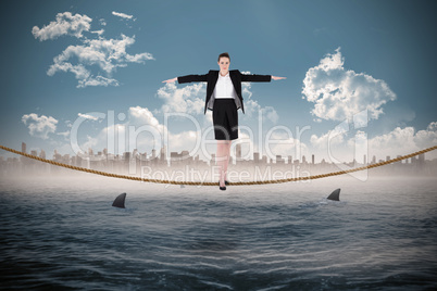 Composite image of businesswoman performing a balancing act